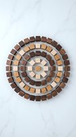 Wooden blocks arranged in concentric circles creating geometric mandala pattern on marble surface for craft projects and educational activities.