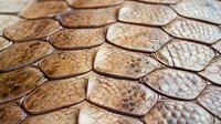 Luxury brown leather texture with hexagonal pattern showcasing rich grain details and natural variations for premium design projects and backgrounds.
