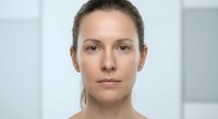 Professional middle-aged Caucasian woman with natural makeup in modern office environment for business and corporate presentations.