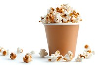 Fresh popcorn in brown paper cup with scattered kernels on white background, caramel and classic mix isolated for snack and entertainment designs.