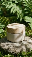 Natural cosmetic jar with wooden lid on stone surface surrounded by lush green ferns for organic skincare and beauty product packaging mockup.