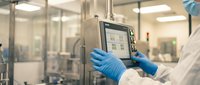 Laboratory technician in blue gloves operating digital control panel in modern pharmaceutical manufacturing facility with sterile environment.