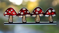 Red spotted mushrooms in a row with crystal rhinestone details on blurred natural background. Decorative woodland design element.