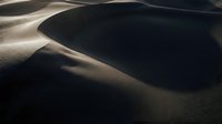 Abstract sand dunes with dramatic shadows and curves creating natural patterns in desert landscape for minimalist design and nature backgrounds.