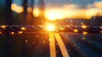 Glowing twisted metal wire against sunset sky with bokeh lights and sun rays creating dramatic atmospheric background effect for technology concept.