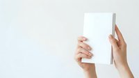 Female hands holding blank white rectangular card or paper against neutral background, suitable for mockups, branding, advertising, and promotional material design.