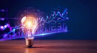 Light bulb with glowing brain and financial charts representing innovation in business analytics and investment strategy on wooden surface.