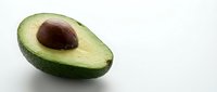 Fresh ripe avocado half with pit on white background, healthy organic fruit for cooking, nutrition and diet concepts, isolated for design use.
