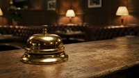 Vintage brass service bell on wooden hotel reception desk in elegant lobby with warm lighting and classic leather furniture for hospitality industry.