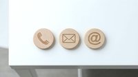 Contact us wooden buttons with phone, mail and email symbols isolated on white background for web design and communication concepts.