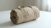 Rolled beige fabric bundle tied with twine on white surface, isolated on neutral background. Suitable for textile, storage, and organization design projects.