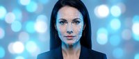 Young professional woman with digital facial recognition dots and blue bokeh lights background for technology and artificial intelligence concepts.