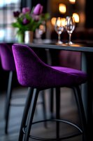 Purple velvet barstool at elegant restaurant table with wine glasses and tulips, soft bokeh lighting creates romantic ambiance for fine dining atmosphere.