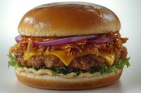 Juicy cheeseburger with melted cheddar, crispy bacon, caramelized onions, fresh lettuce and special sauce on toasted brioche bun, close up food photography.