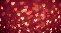 Romantic red and gold heart-shaped bokeh lights creating warm Valentine's Day atmosphere for love celebrations and wedding decorations.