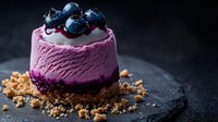 Mini purple cheesecake topped with fresh blueberries and crumble base on dark stone background, dramatic moody food photography for dessert menu.