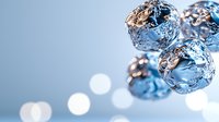 Shiny metallic spheres with crumpled foil texture floating in blue atmosphere with soft bokeh lights creating dreamy, abstract composition. Suitable for luxury designs.