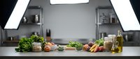 Fresh organic vegetables and ingredients arranged on modern kitchen counter for healthy cooking and meal preparation.