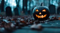 Glowing carved pumpkin with classic jack-o-lantern face in spooky misty graveyard at dusk among fallen autumn leaves, creating eerie Halloween atmosphere.