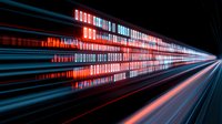 Futuristic digital binary code streaming through space with glowing red and blue light trails creating dynamic motion effect against dark background.