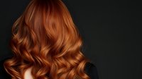 Luxurious copper red wavy hair on dark background, professional hairstyle with soft curls and natural shine. Perfect for beauty and hair care advertising.