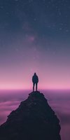 Silhouette of person standing on mountain peak against starry purple night sky and misty clouds, creating atmospheric dreamy landscape for inspiration and adventure.