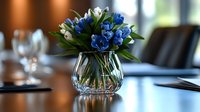 Fresh blue gentiana and white flowers arranged in crystal vase on glossy restaurant table, elegant dining atmosphere with soft background blur and wine glasses.