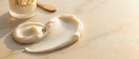 Creamy beige foundation makeup spilled on wooden surface with cosmetic brush, beauty product accident mess for skincare and cosmetics advertising.