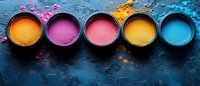 Vibrant colorful powder pigments in round containers on dark textured background. Pink, orange, yellow and blue natural dye scattered on surface. Artistic makeup concept.