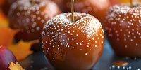 Caramel coated apples decorated with white sugar pearls on dark background, autumn seasonal treats and Halloween party dessert for festive celebration.