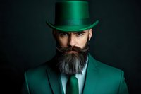 Bearded man in emerald green suit and top hat against dark background, dramatic studio lighting highlights facial features and fashion details.