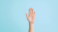 Raised hand gesture against light blue background showing palm facing forward, symbolizing stop, hello, high five or voting concept for business presentations.