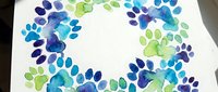 Colorful watercolor paw prints in blue and green tones scattered on white paper background. Pet care, veterinary, animal lover concept for creative projects.