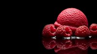 Vibrant red raspberry ice cream scoop and fresh raspberries arranged on reflective black surface with dramatic lighting creating mirror effect and dark background.