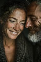 Happy mature couple embracing intimately, showing genuine love and connection in warm natural lighting with authentic expressions and freckled skin.