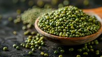 Fresh green mung beans in wooden bowl on dark background, nutritious legumes for healthy cooking and plant-based protein source.