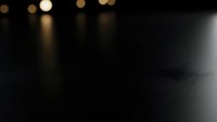 Dark abstract background with warm golden bokeh lights and bright spotlight creating dramatic atmosphere for presentations and design projects.