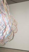 Iridescent fiber optic installation art piece with rainbow colored strands creating abstract sculptural form in modern gallery space for contemporary design.