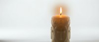 Burning candle with warm flame creating soft glow and peaceful ambiance for relaxation meditation spa wellness aromatherapy home decor lighting atmosphere.