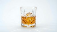 Crystal whiskey glass with amber liquor and ice cube on white background, isolated for luxury beverage design and bar concept applications.