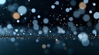 Dreamy bokeh lights floating over dark reflective surface create magical atmosphere with blue and golden glowing orbs against black background.