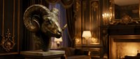 Ornate golden ram head sculpture displayed on pedestal in luxurious interior with warm lighting, fireplace, and classical decor. Perfect for luxury design, home decor, and upscale interior styling projects.