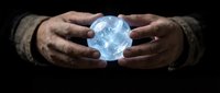 Hands of a middle-aged male with dark skin tone holding a glowing blue crystal ball or orb against black background, symbolizing fortune telling, mysticism, spirituality, and future prediction for divination concepts.
