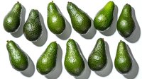 Fresh ripe green avocados arranged in rows on white background with natural shadows, top view. Clean minimal food photography style for healthy eating concept.