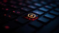 Illuminated gaming keyboard key with cryptocurrency bitcoin symbol glowing in red and orange against dark background, macro photography closeup.