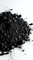 Pile of finely ground black powder or charcoal dust scattered on white surface, suitable for cosmetics, art, industrial, or educational materials.