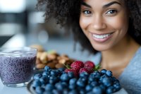 Young African American woman enjoying healthy breakfast with fresh berries and smoothie bowl in modern kitchen for wellness lifestyle content.
