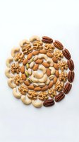 Mixed nuts arranged in circular pattern on white background including walnuts cashews almonds pecans and pistachios for healthy snacking and cooking.