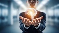 Businessman holding glowing brain with neural network connections in modern office environment representing artificial intelligence and innovation.
