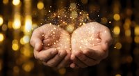 Cupped hands holding magical golden sparkles and glittering particles against warm bokeh lights background for festive celebrations and wish concepts.